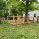 A farm wooden fence constructed from vertical planks, showcasing a natural wood finish and sturdy design.