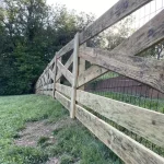 A farm wooden fence constructed from vertical planks, showcasing a natural wood finish and sturdy design.