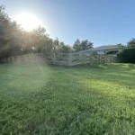 A farm wooden fence constructed from vertical planks, showcasing a natural wood finish and sturdy design.