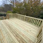 A wooden deck featuring stairs, surrounded by greenery, inviting for relaxation and outdoor gatherings.