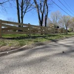 A farm wooden fence constructed from vertical planks, showcasing a natural wood finish and sturdy design.