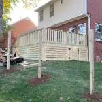 A wooden deck featuring stairs, surrounded by greenery, inviting for relaxation and outdoor gatherings.
