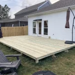 A wooden deck under construction, surrounded by greenery, inviting for relaxation and outdoor gatherings.