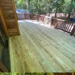A wooden deck featuring stairs, surrounded by greenery, inviting for relaxation and outdoor gatherings.