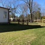 A farm wooden fence constructed from vertical planks, showcasing a natural wood finish and sturdy design.
