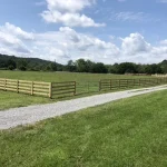 A farm wooden fence constructed from vertical planks, showcasing a natural wood finish and sturdy design.