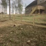 A farm wooden fence constructed from vertical planks, showcasing a natural wood finish and sturdy design.